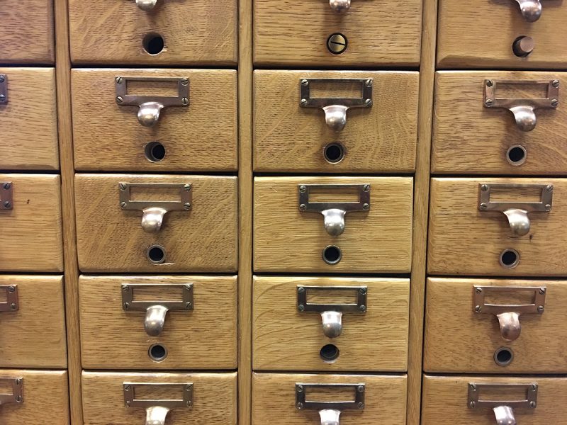 Rows of small wooden drawers with brass label holders