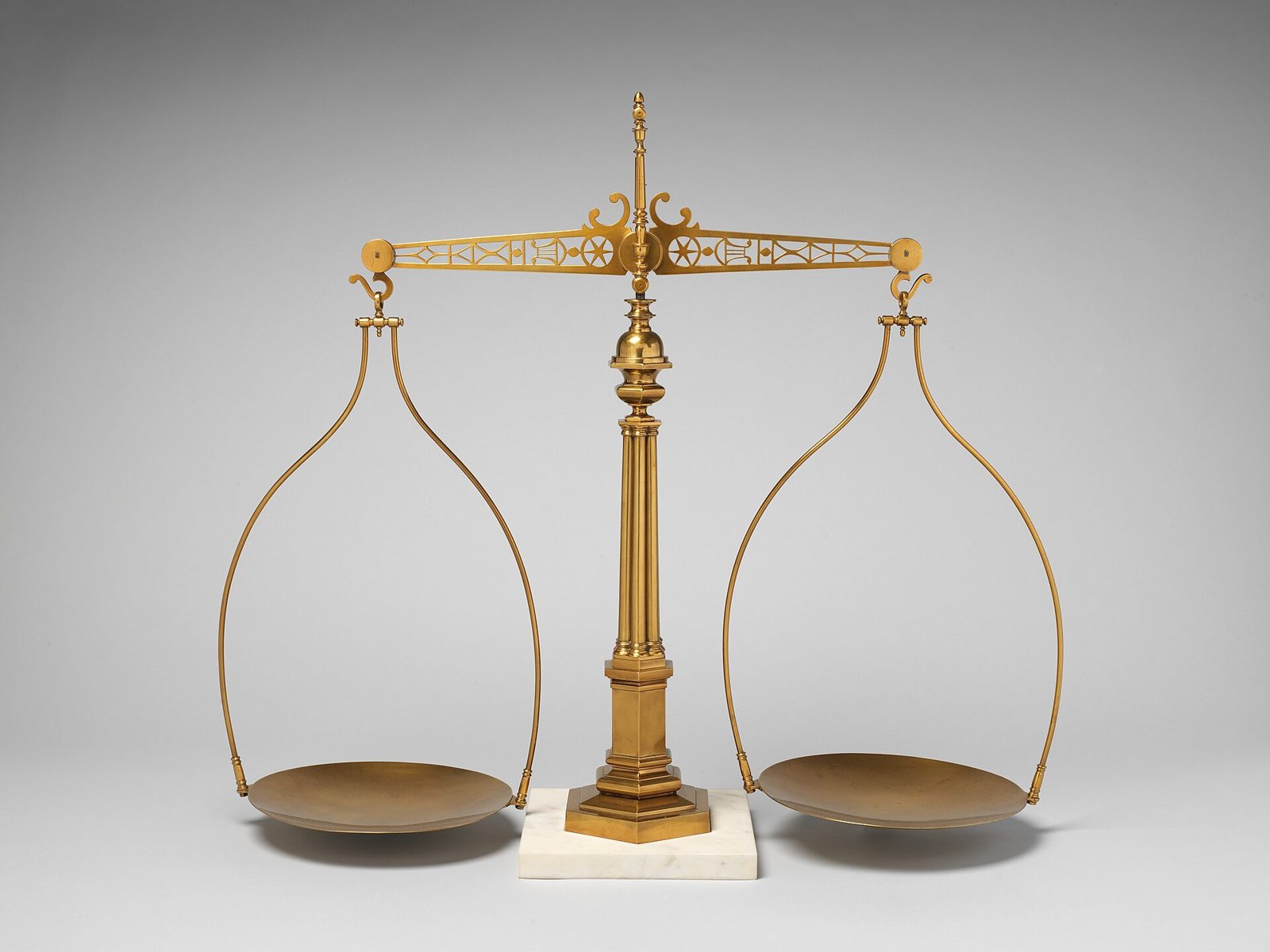 A gilded balance scale with two hanging pans