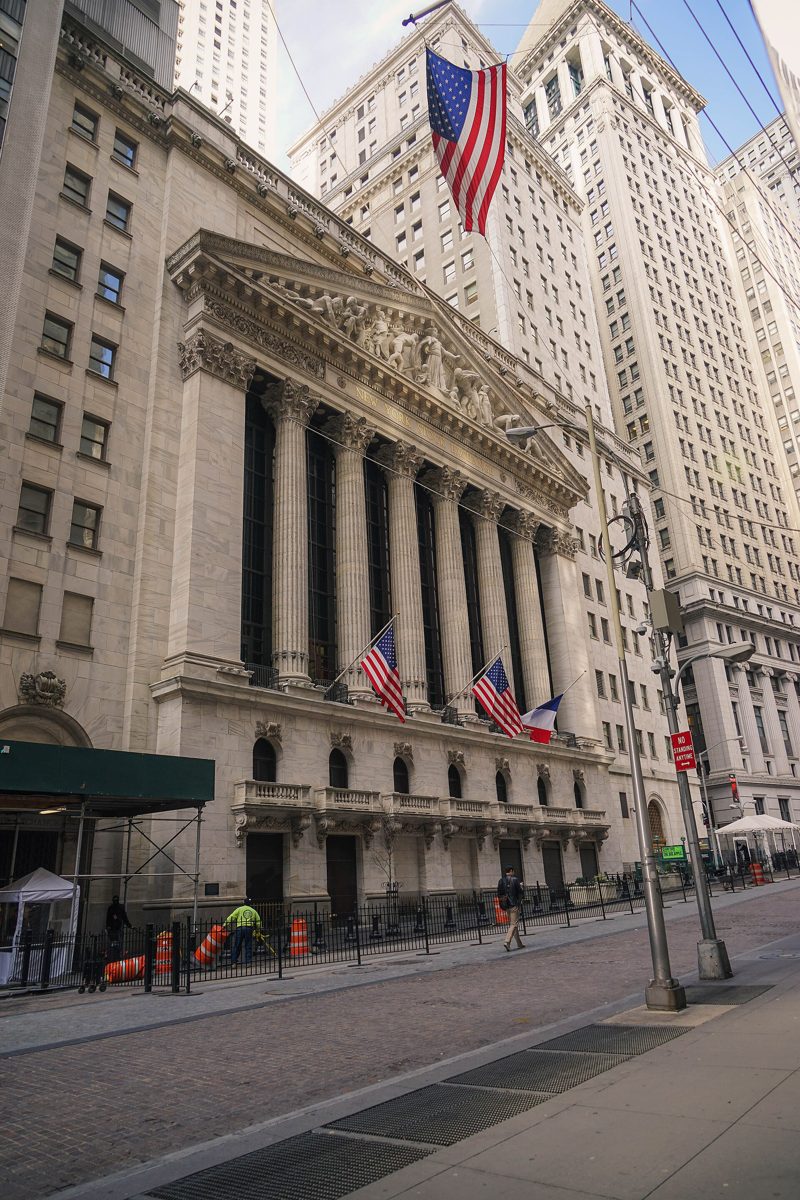 The columned facade of the New York Stock Exchange with an American flag